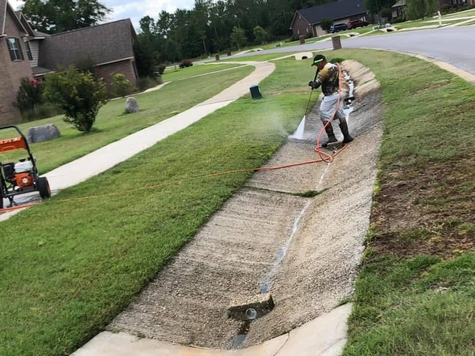 Pressure washing a concrete drainage swale