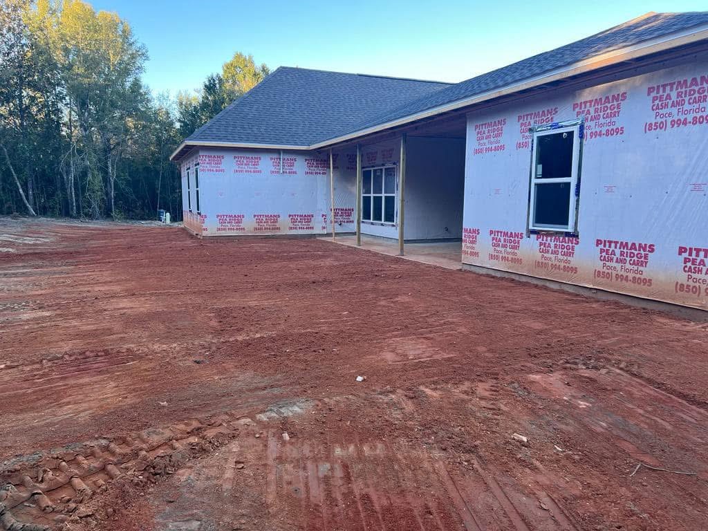 Freshly graded dirt pad around a new home under construction